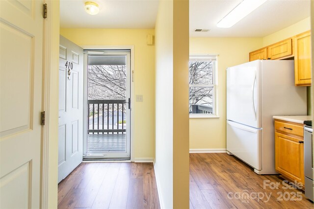 doorway featuring wood finished floors, visible vents, and baseboards