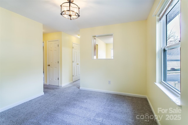 spare room featuring carpet flooring, a healthy amount of sunlight, and baseboards