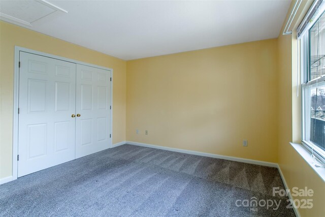 unfurnished bedroom featuring carpet floors, multiple windows, and baseboards