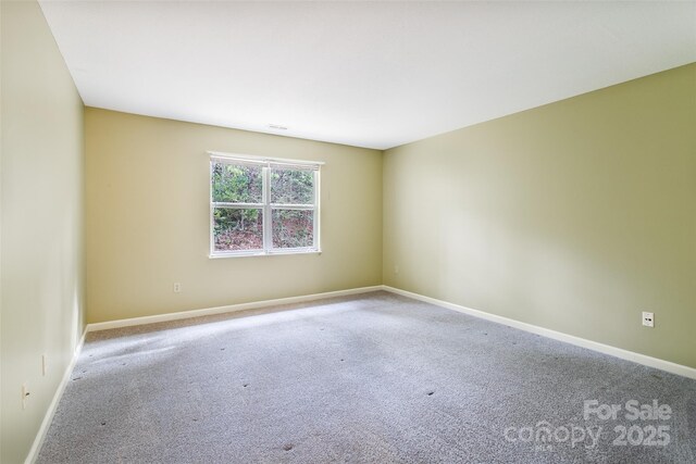 carpeted empty room featuring baseboards