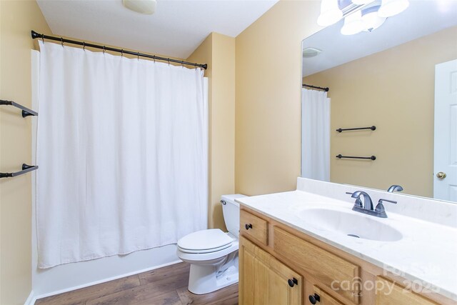 full bathroom with vanity, shower / bath combination with curtain, wood finished floors, and toilet