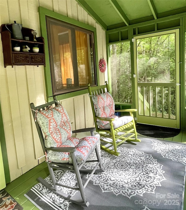 sunroom / solarium with lofted ceiling and a healthy amount of sunlight