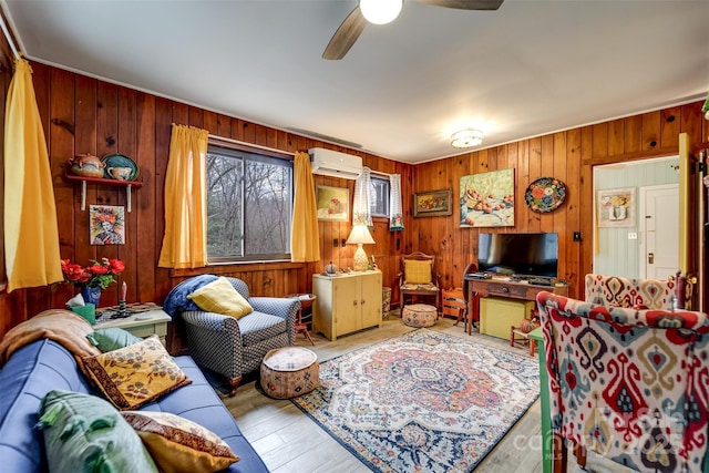 living room with wooden walls, ceiling fan, a wall mounted AC, and light hardwood / wood-style flooring