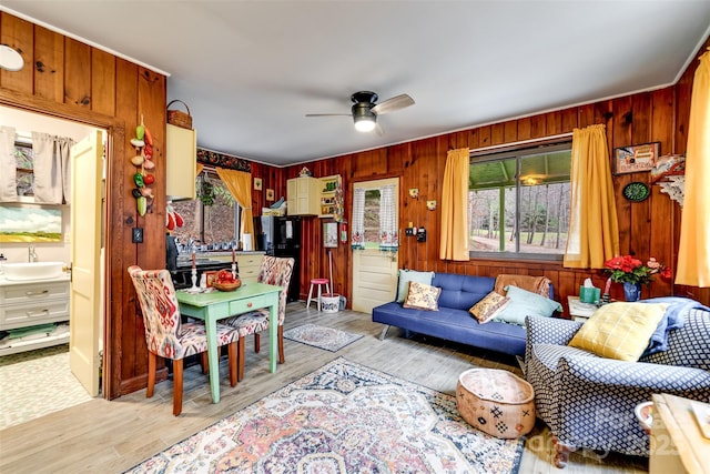 living room with ceiling fan, sink, and light hardwood / wood-style flooring