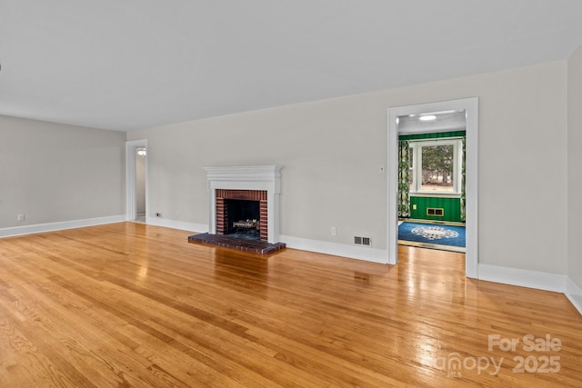 unfurnished living room featuring a fireplace and light hardwood / wood-style flooring