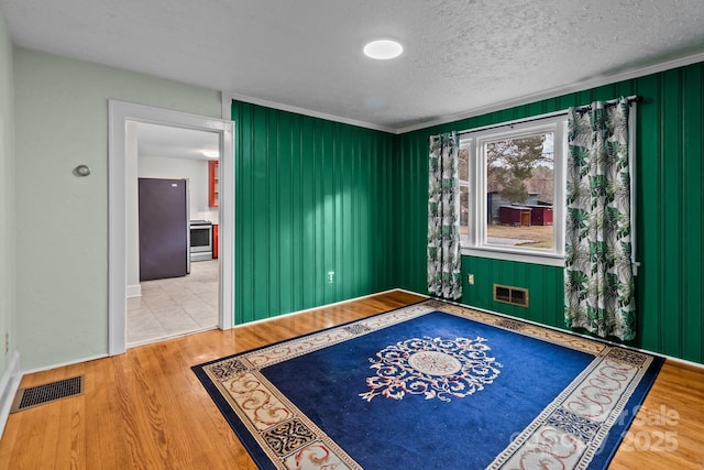 spare room featuring wood-type flooring and a textured ceiling