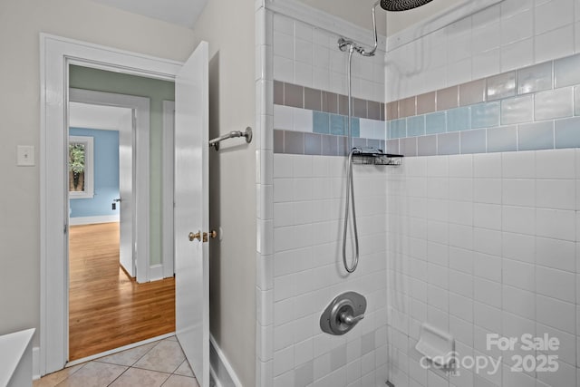 bathroom with a tile shower and tile patterned floors