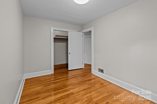 unfurnished bedroom featuring light wood-type flooring and a closet