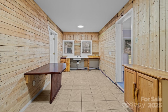 kitchen featuring wood walls and light tile patterned floors