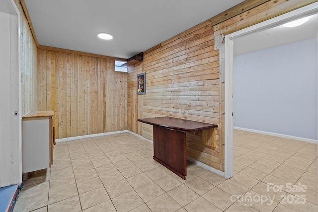 interior space with wood walls and light tile patterned flooring