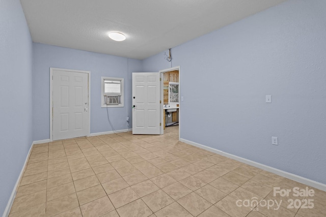 tiled empty room with cooling unit and a textured ceiling