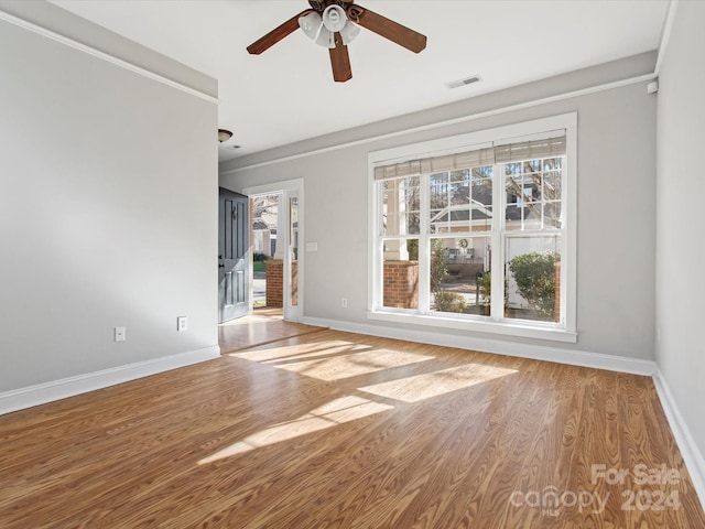 unfurnished living room featuring light wood-type flooring, ceiling fan, and crown molding