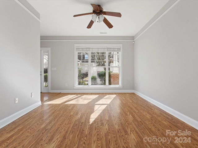 spare room featuring ceiling fan, light wood-type flooring, and crown molding