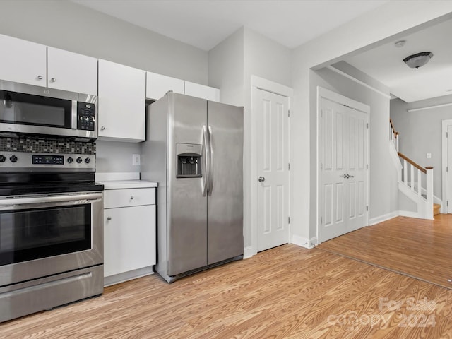 kitchen featuring white cabinets, stainless steel appliances, and light hardwood / wood-style flooring