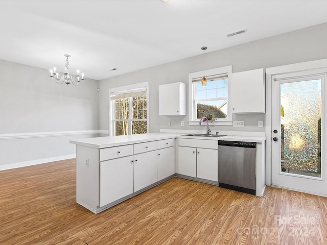 kitchen with stainless steel dishwasher, decorative light fixtures, and kitchen peninsula