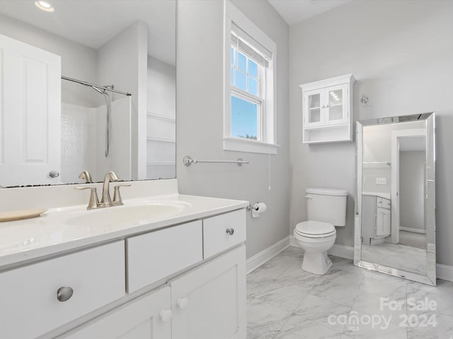 bathroom featuring vanity, toilet, and walk in shower