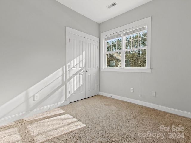 spare room featuring light colored carpet