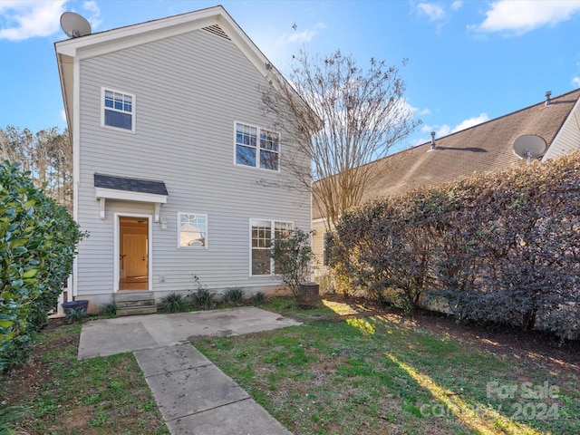 rear view of property featuring a lawn