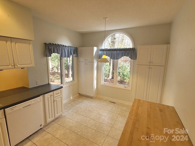 unfurnished dining area with light tile patterned floors and a textured ceiling