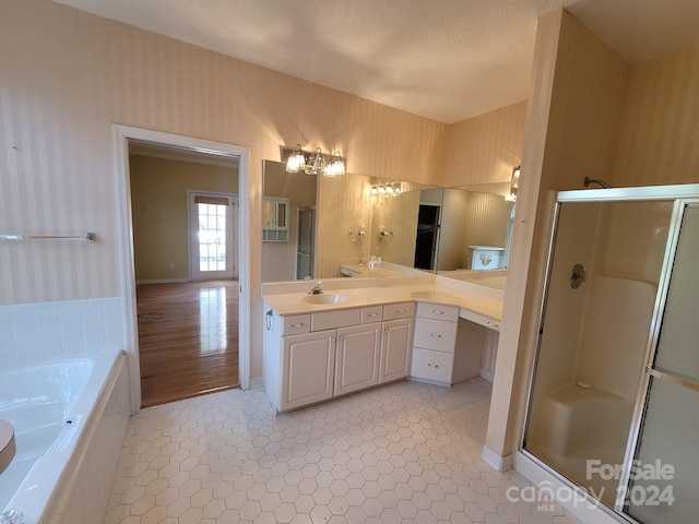 bathroom featuring hardwood / wood-style flooring, vanity, separate shower and tub, and a textured ceiling