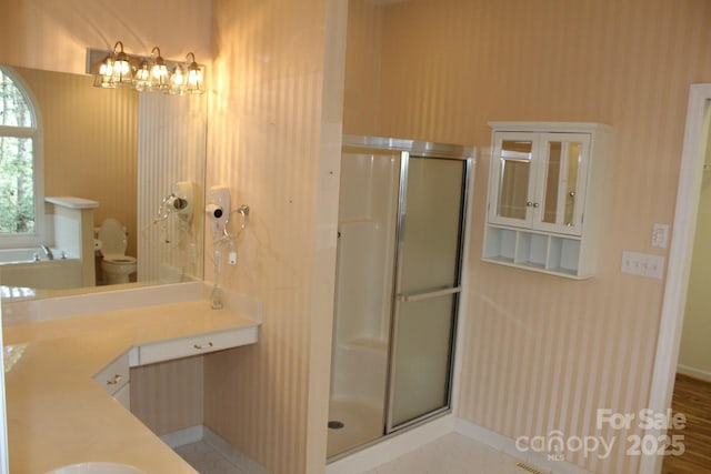 bathroom featuring a shower with door, vanity, tile patterned floors, and toilet