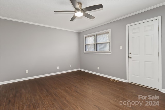 empty room with dark hardwood / wood-style floors, ceiling fan, and ornamental molding