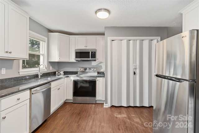 kitchen with white cabinets, dark hardwood / wood-style flooring, sink, and appliances with stainless steel finishes