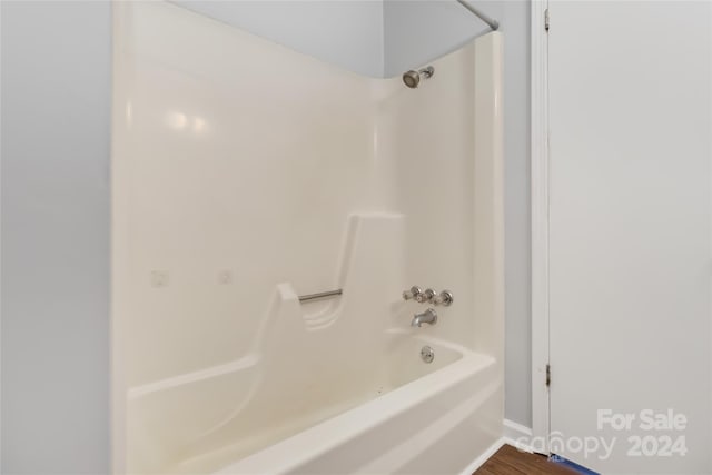 bathroom with hardwood / wood-style floors and bathtub / shower combination