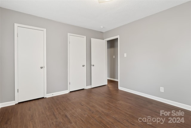 unfurnished bedroom featuring dark hardwood / wood-style flooring and a textured ceiling