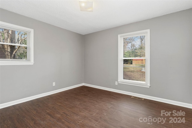 unfurnished room with dark hardwood / wood-style floors and a textured ceiling