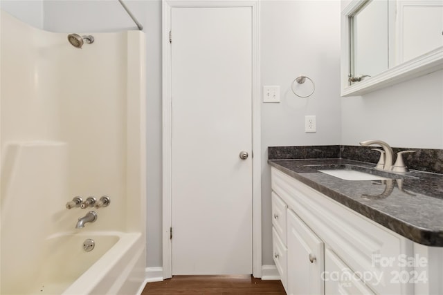 bathroom featuring vanity, wood-type flooring, and tub / shower combination