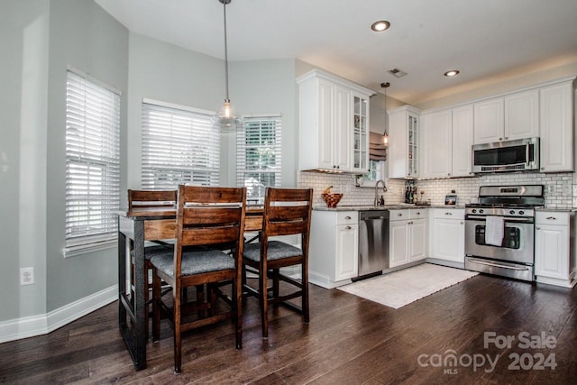 kitchen featuring hanging light fixtures, white cabinets, and stainless steel appliances