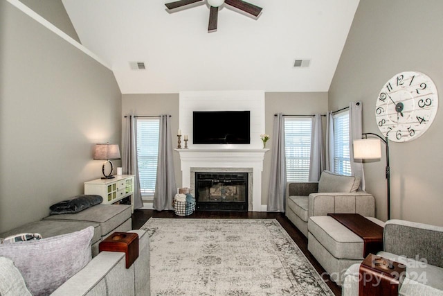 living room with a healthy amount of sunlight, a large fireplace, and lofted ceiling