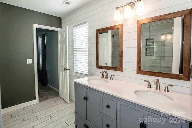 bathroom with hardwood / wood-style floors, vanity, and wood walls