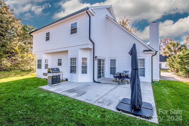 rear view of house with a yard and a patio area