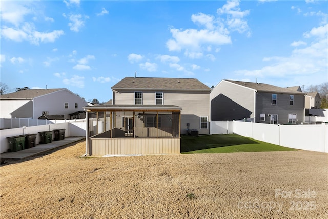 rear view of house with a sunroom and a yard