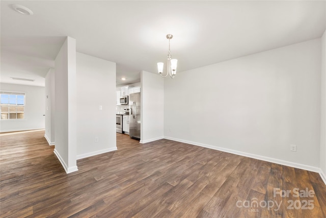 empty room featuring dark wood-type flooring and an inviting chandelier