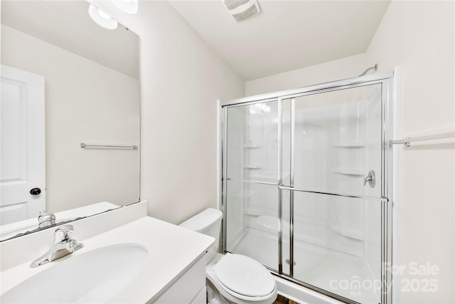 bathroom with vanity, a shower with shower door, and toilet