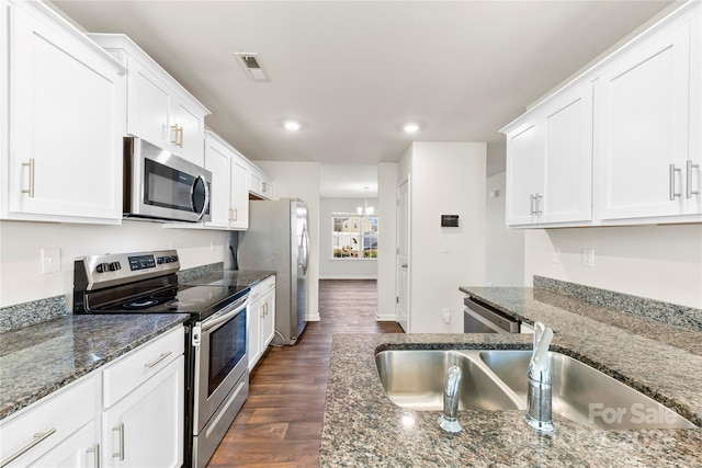 kitchen featuring sink, dark stone counters, white cabinets, and appliances with stainless steel finishes