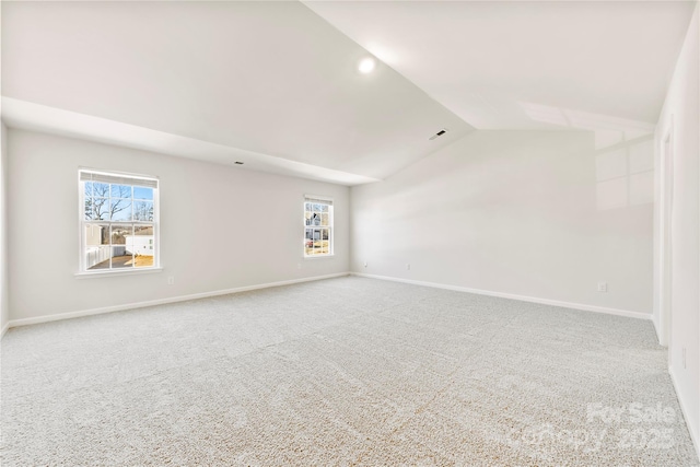 empty room featuring lofted ceiling and carpet floors