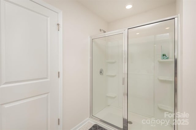 bathroom featuring a shower with shower door and tile patterned flooring