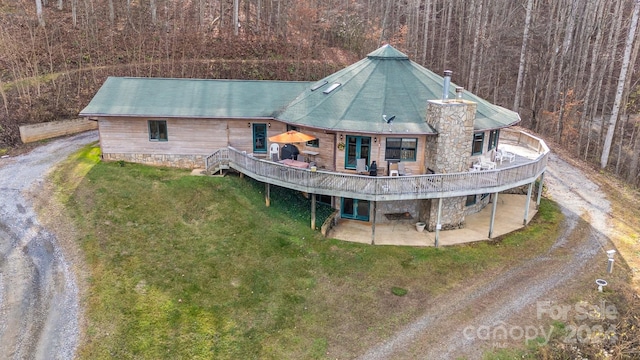 rear view of house featuring a yard and a wooden deck