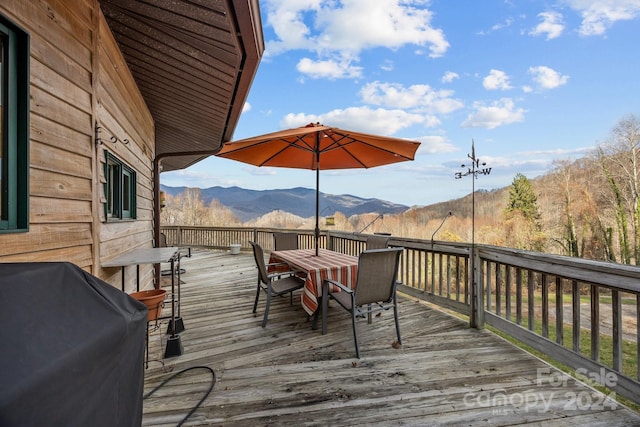 wooden deck with a mountain view and a grill