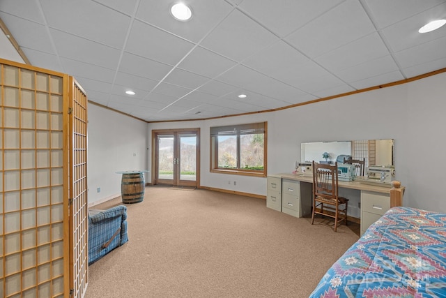 carpeted bedroom featuring a paneled ceiling, crown molding, and french doors