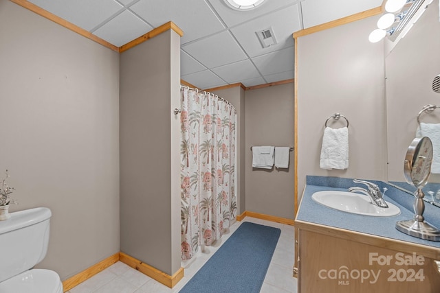 bathroom featuring tile patterned floors, a drop ceiling, vanity, and toilet