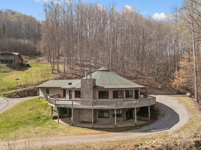 417 Quiet Forest Ln, Sylva, NC 28779 - back of house with driveway, a lawn, a deck, a patio area, and stone siding