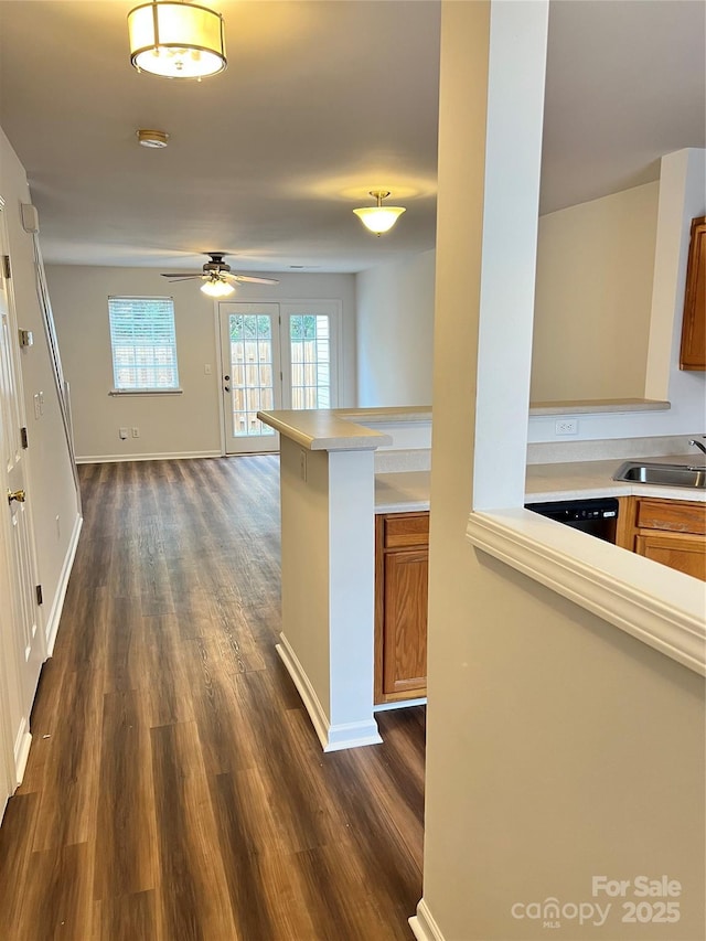 kitchen with dark hardwood / wood-style floors, dishwasher, sink, ceiling fan, and kitchen peninsula