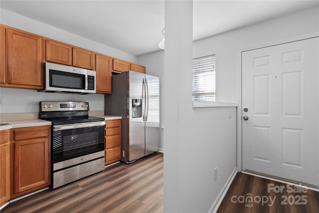 kitchen featuring appliances with stainless steel finishes and dark hardwood / wood-style flooring