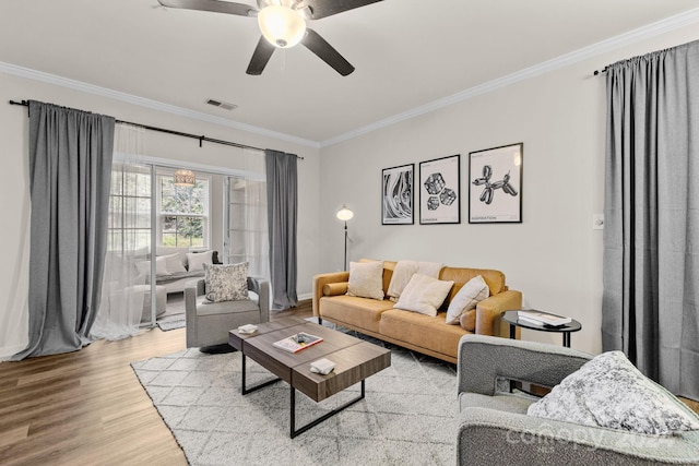 living room featuring ceiling fan, ornamental molding, and hardwood / wood-style flooring