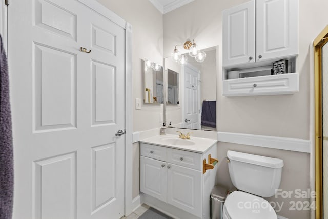 bathroom featuring vanity, toilet, and crown molding